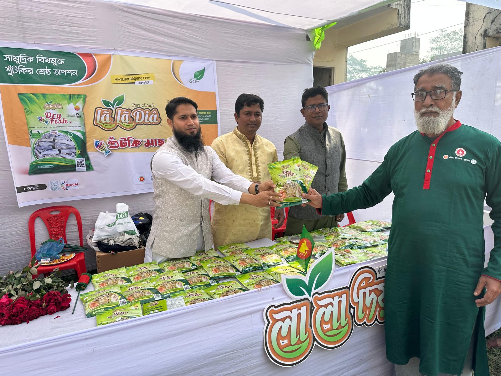 প্রদর্শনীর স্টলে একজন অতিথির হাতে লা লা দিয়ার শুঁটকি মাছের প্যাকেট তুলে দেওয়া হচ্ছে